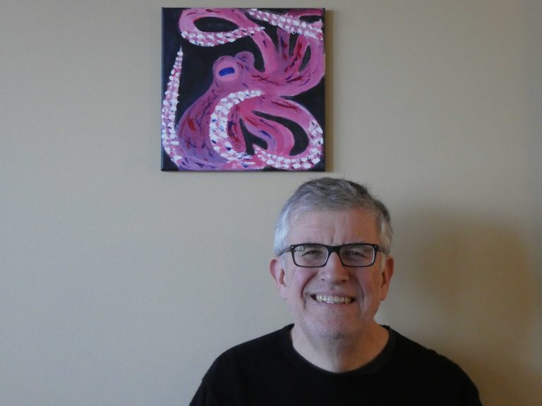 Photo of Christian in front of Octopus logo
